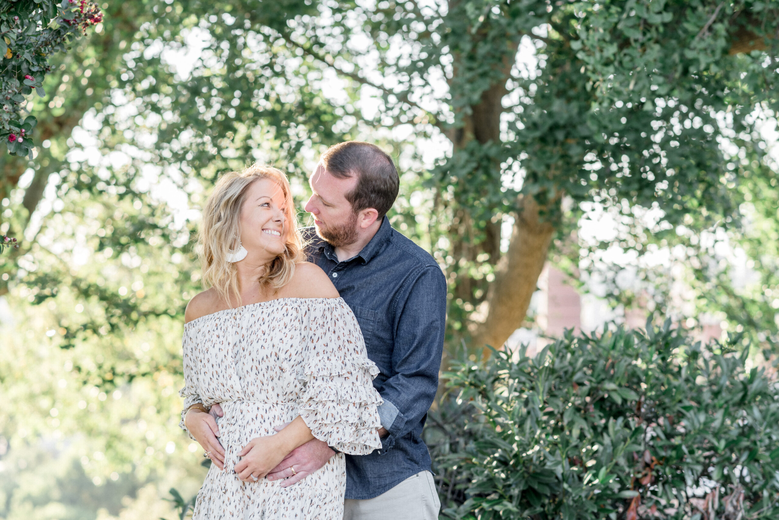 mother and father to be laughing together during pregnancy announcement photo session