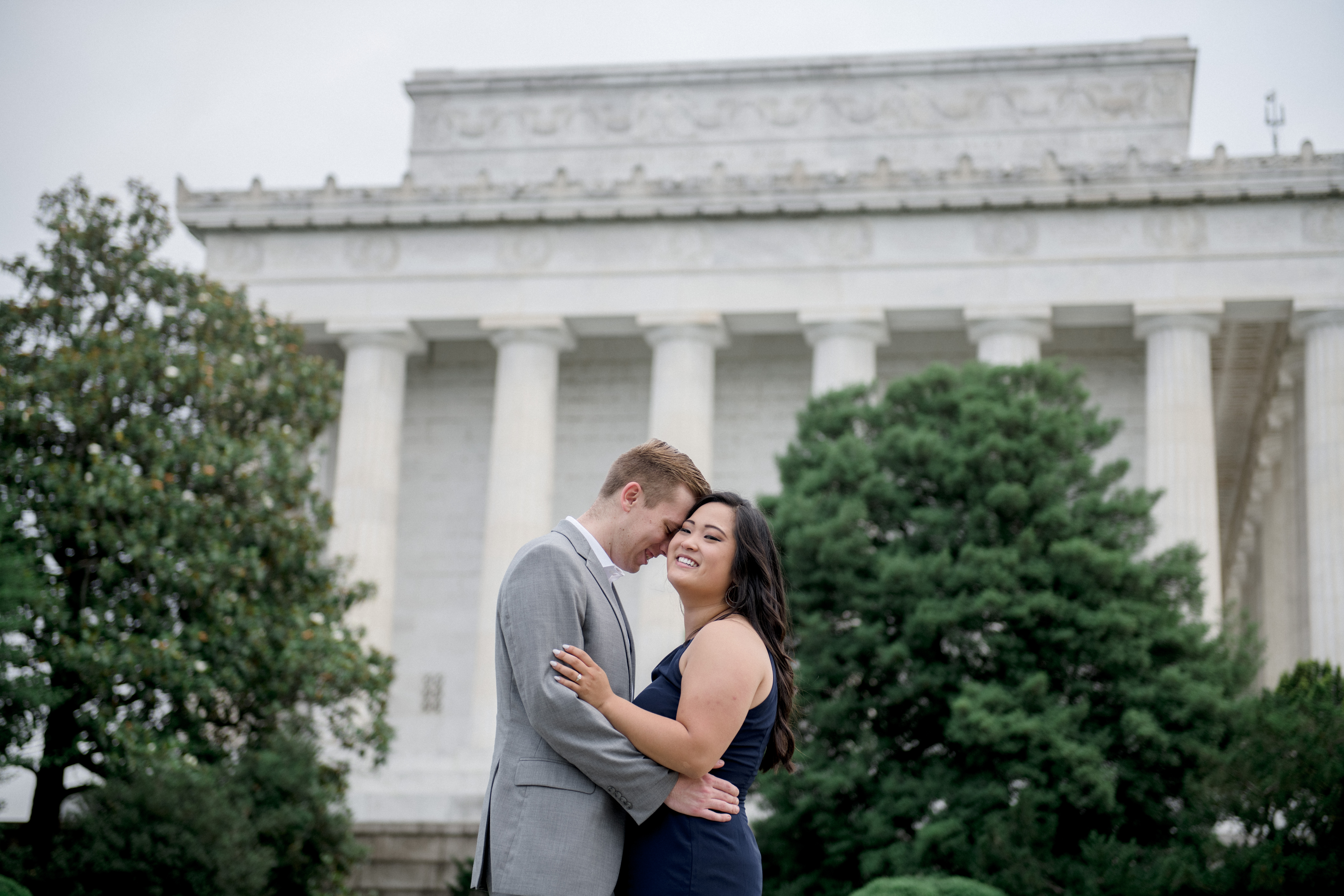 Engaged couple taking professional portraits in front of the Lincoln memorial