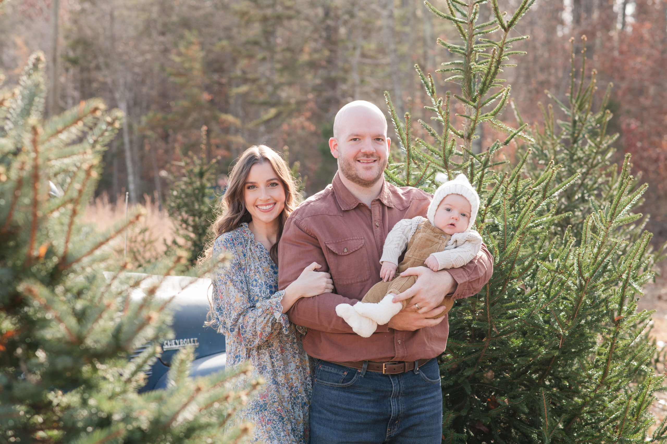 Family of three in christmas tree farm
