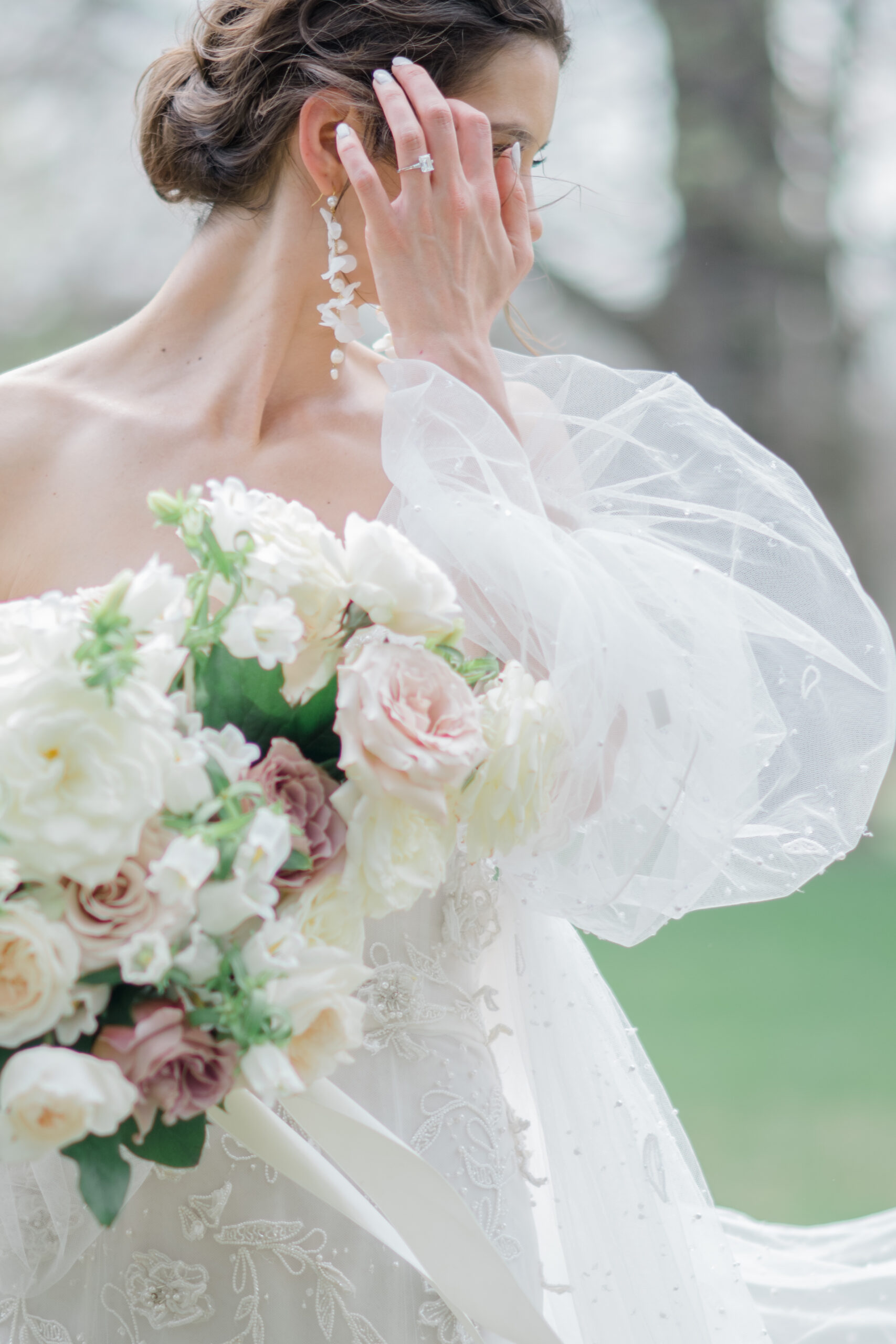 Bride in flowing wedding dress and cape with magical bridal bouquet 