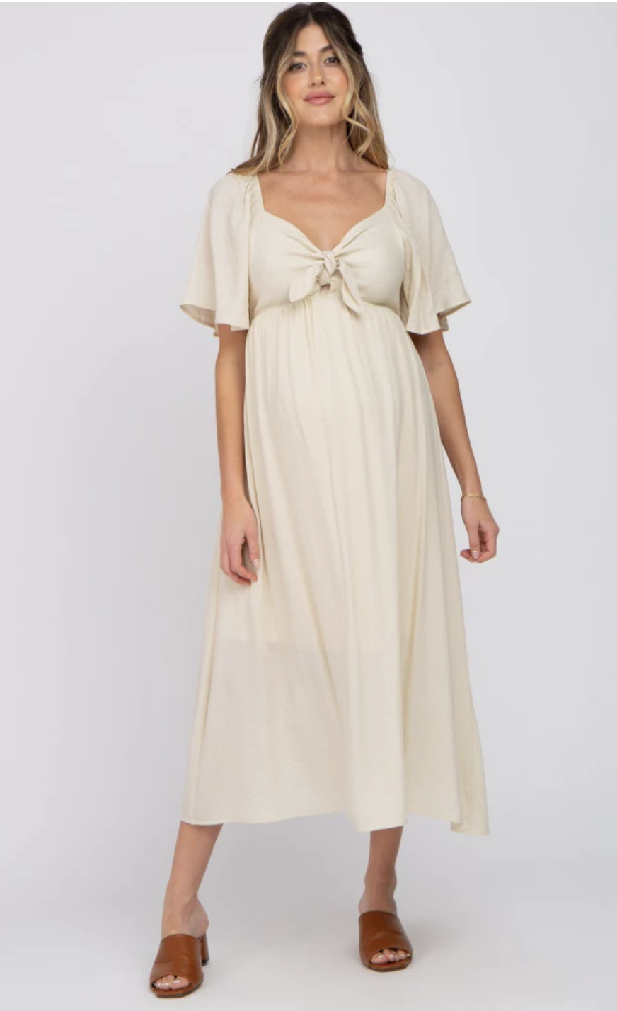 Cream maternity midi dress with a front tie detail and flutter sleeves, styled with brown sandals – ideal for soft, neutral family photo sessions.