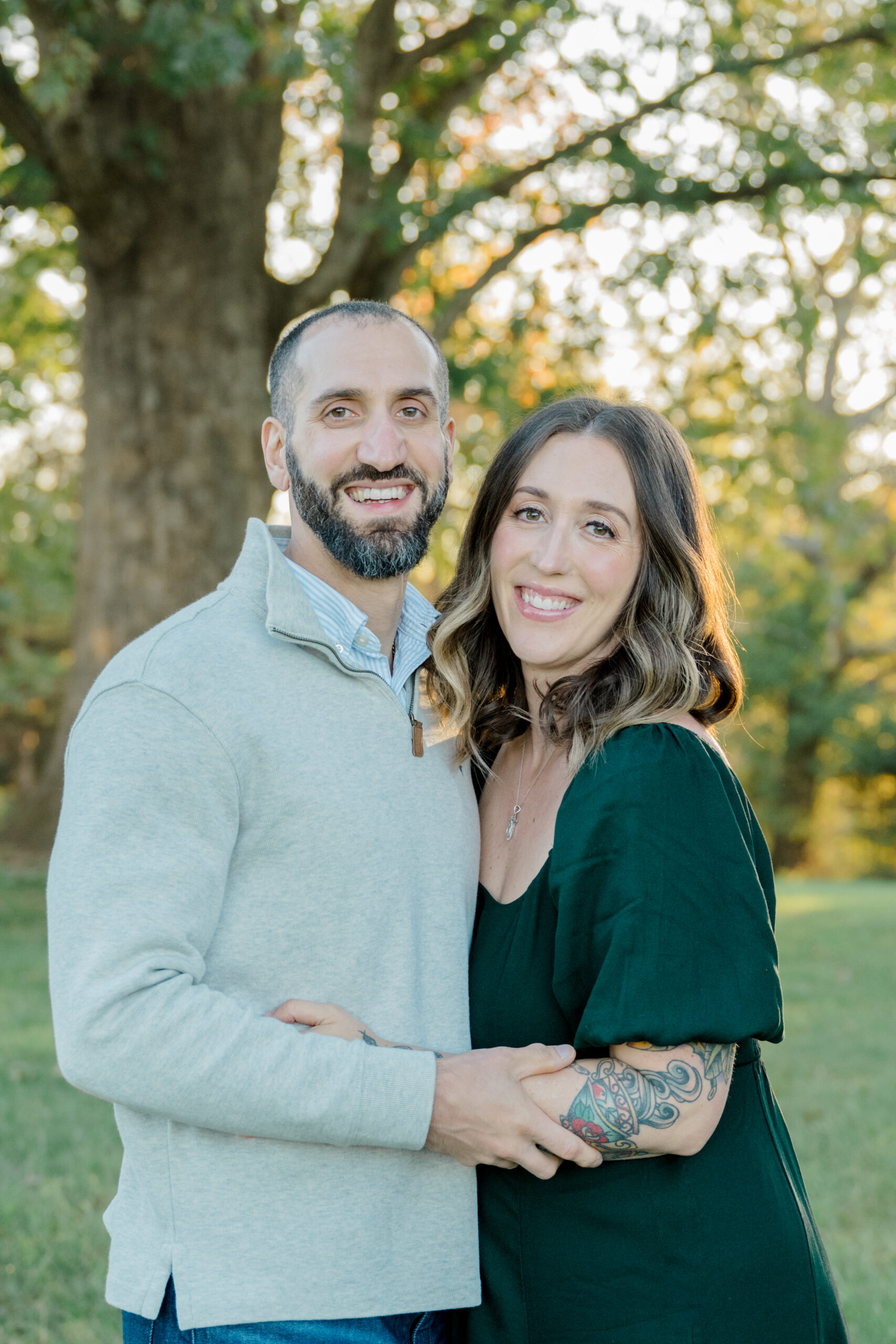 Parents share a warm smile during their Fluvanna family photo session, capturing a loving moment during golden hour at Pleasant Grove Park.