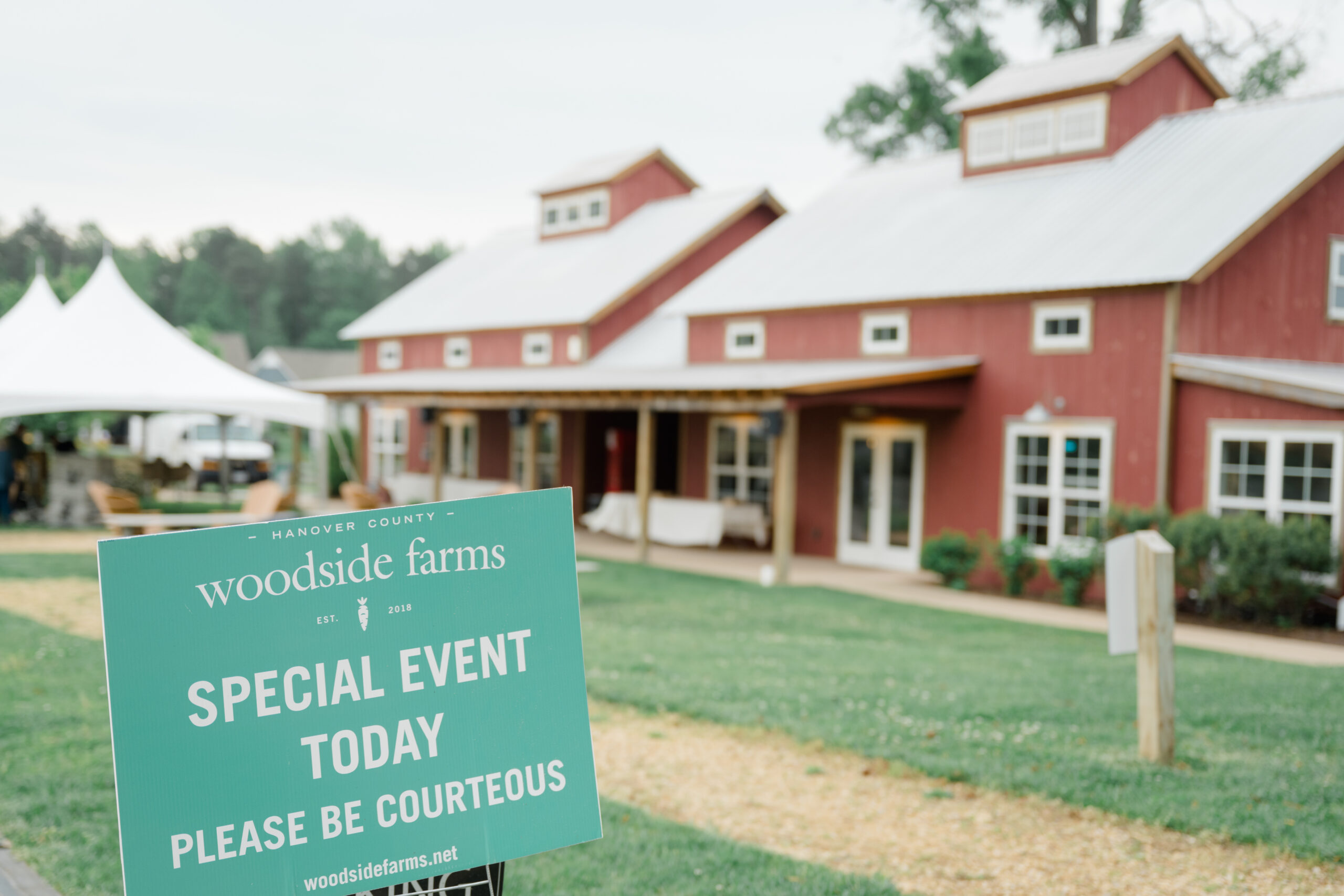 Special event sign in front of the red barn at Woodside Farms wedding venue, indicating a wedding is taking place.