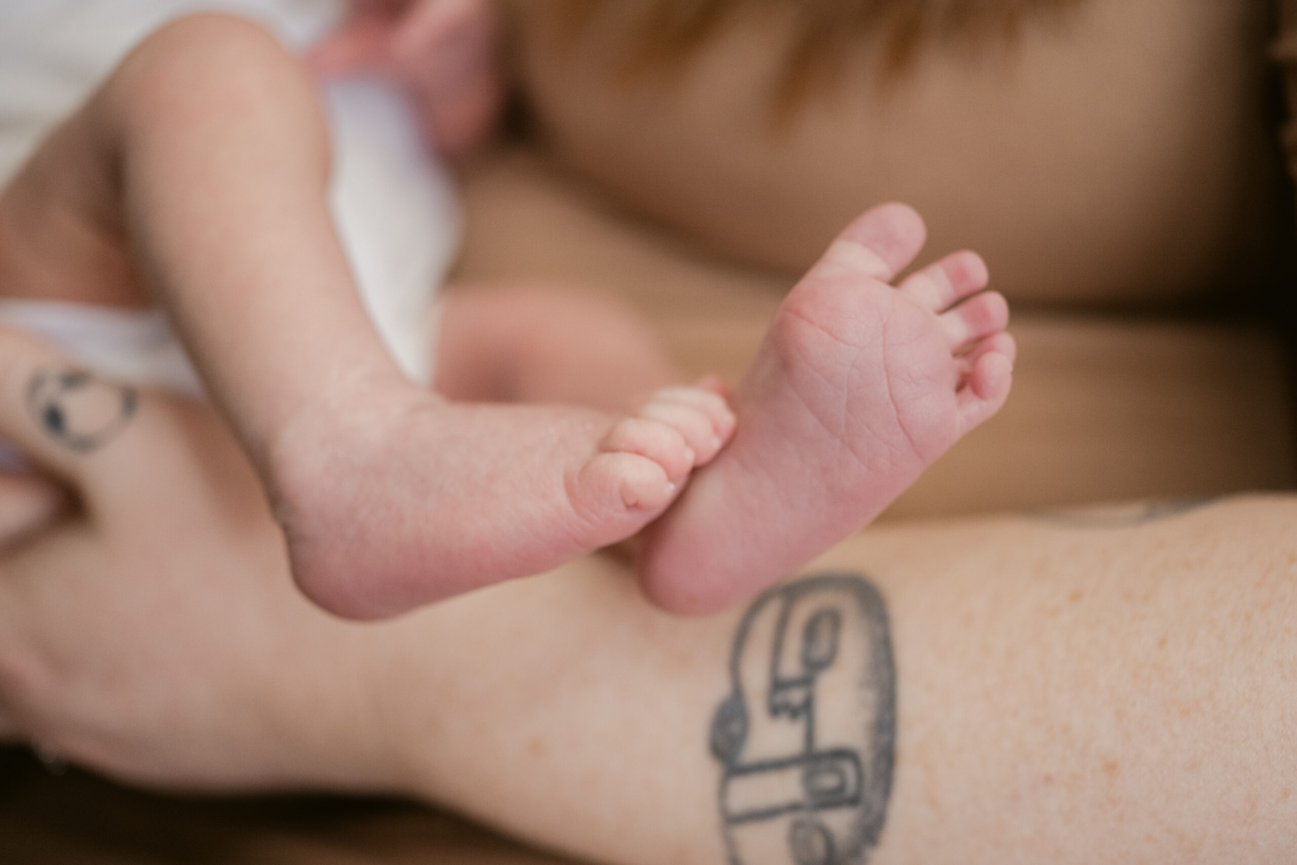 Lifestyle newborn photo of a new mom cradling her baby in soft window light inside their Mechanicsville, Virginia home.