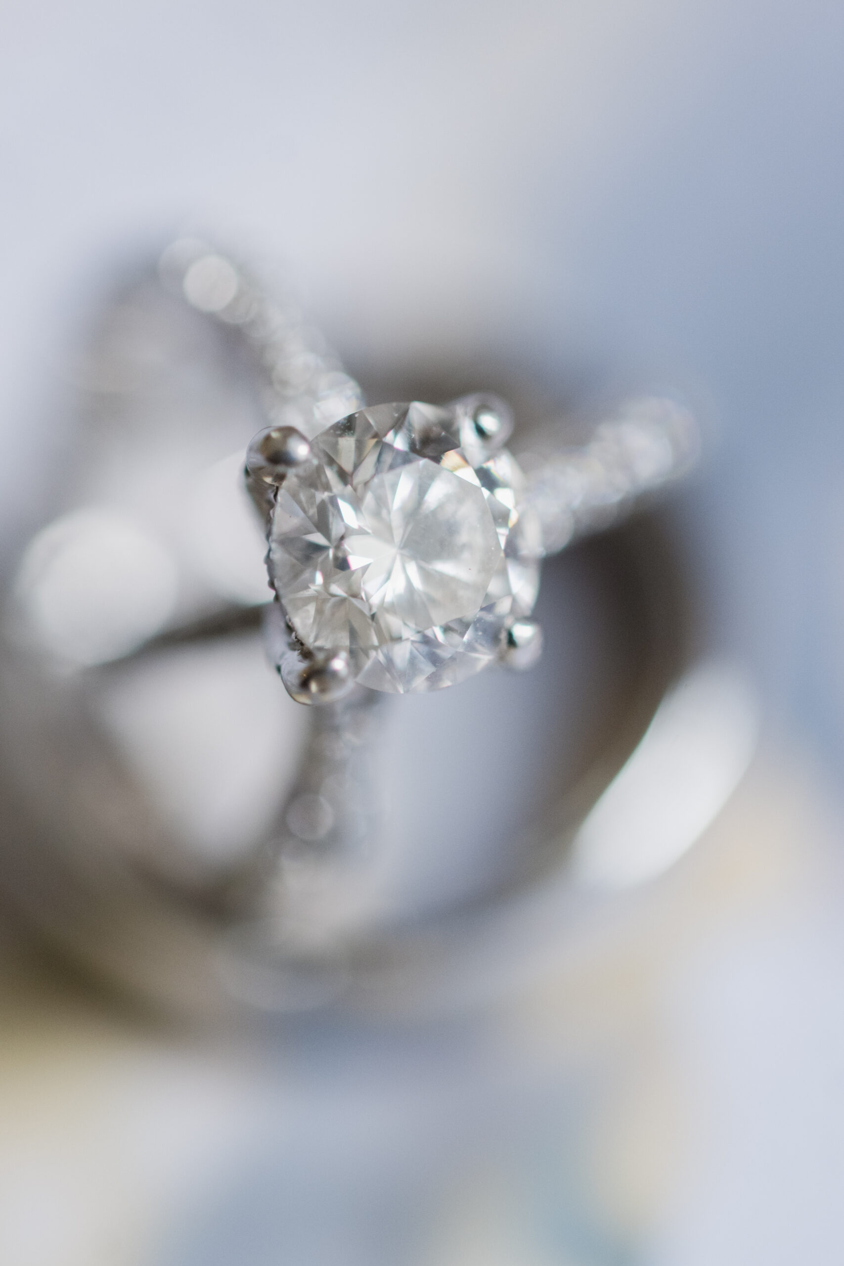 Close-up of a diamond engagement ring with a round brilliant cut and pave band, photographed in natural light for a Springfield Manor wedding detail shot.