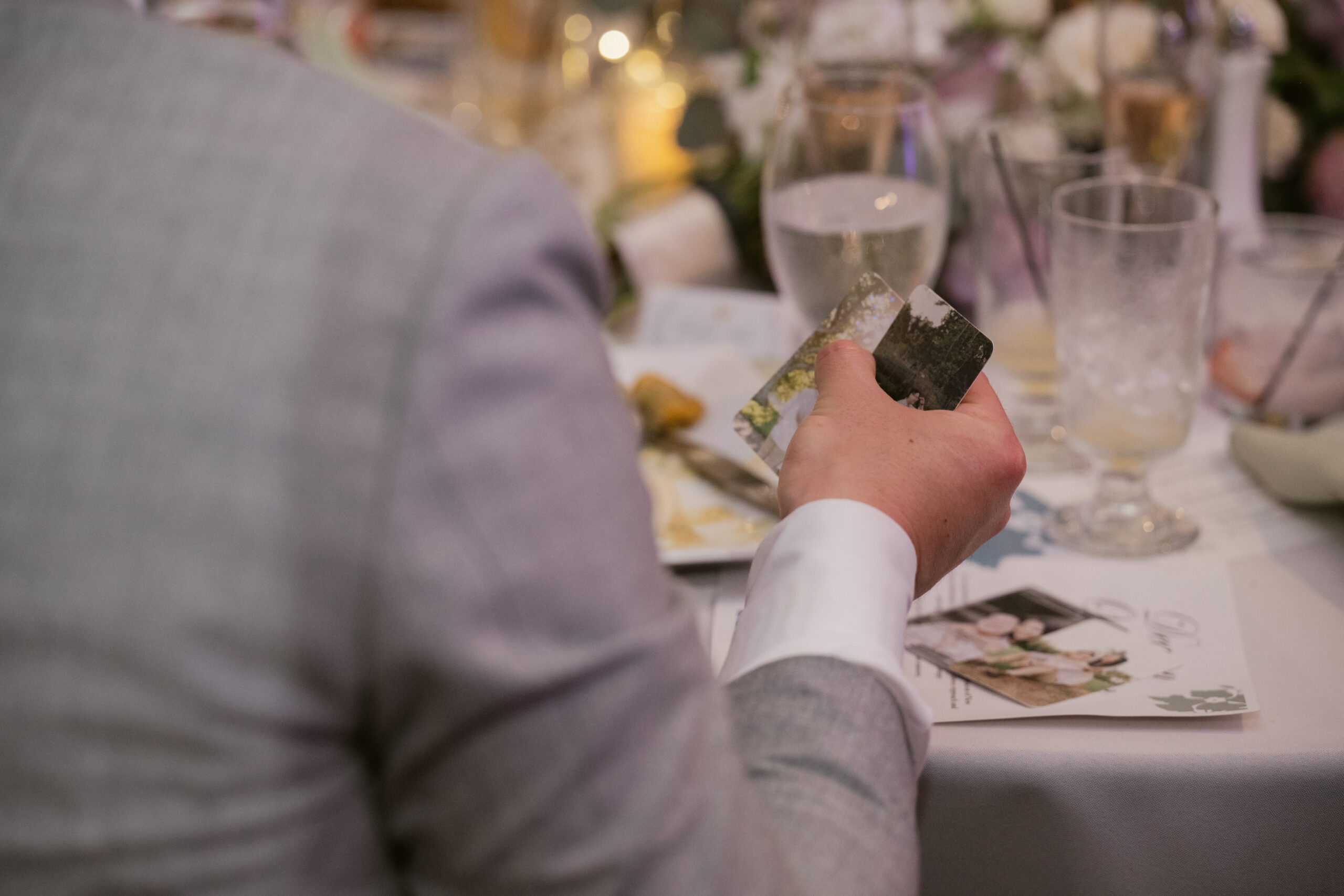 Guest holding customized cards featuring the couple’s photos during the wedding reception.