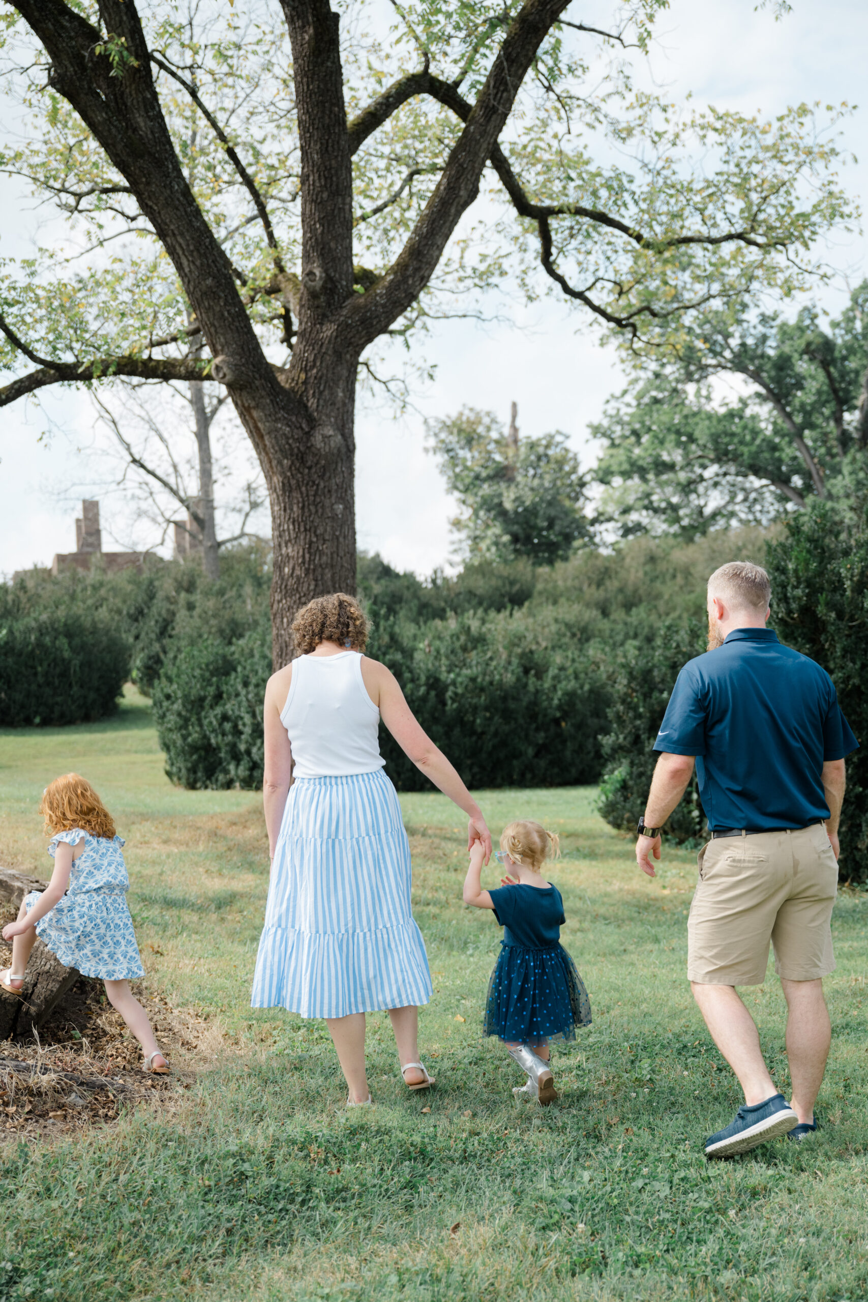 Family walking hand-in-hand through the vineyard at Barboursville Vineyards in Virginia.