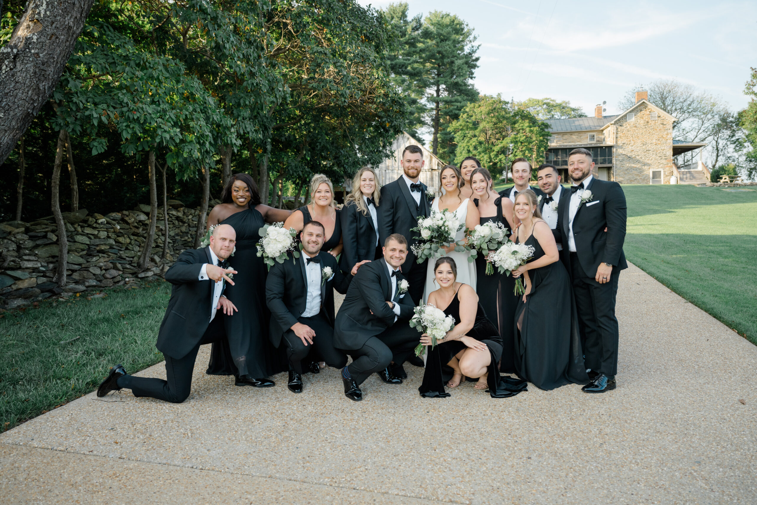 Bride and groom surrounded by their wedding party during joyful group portraits at Gordon Springs