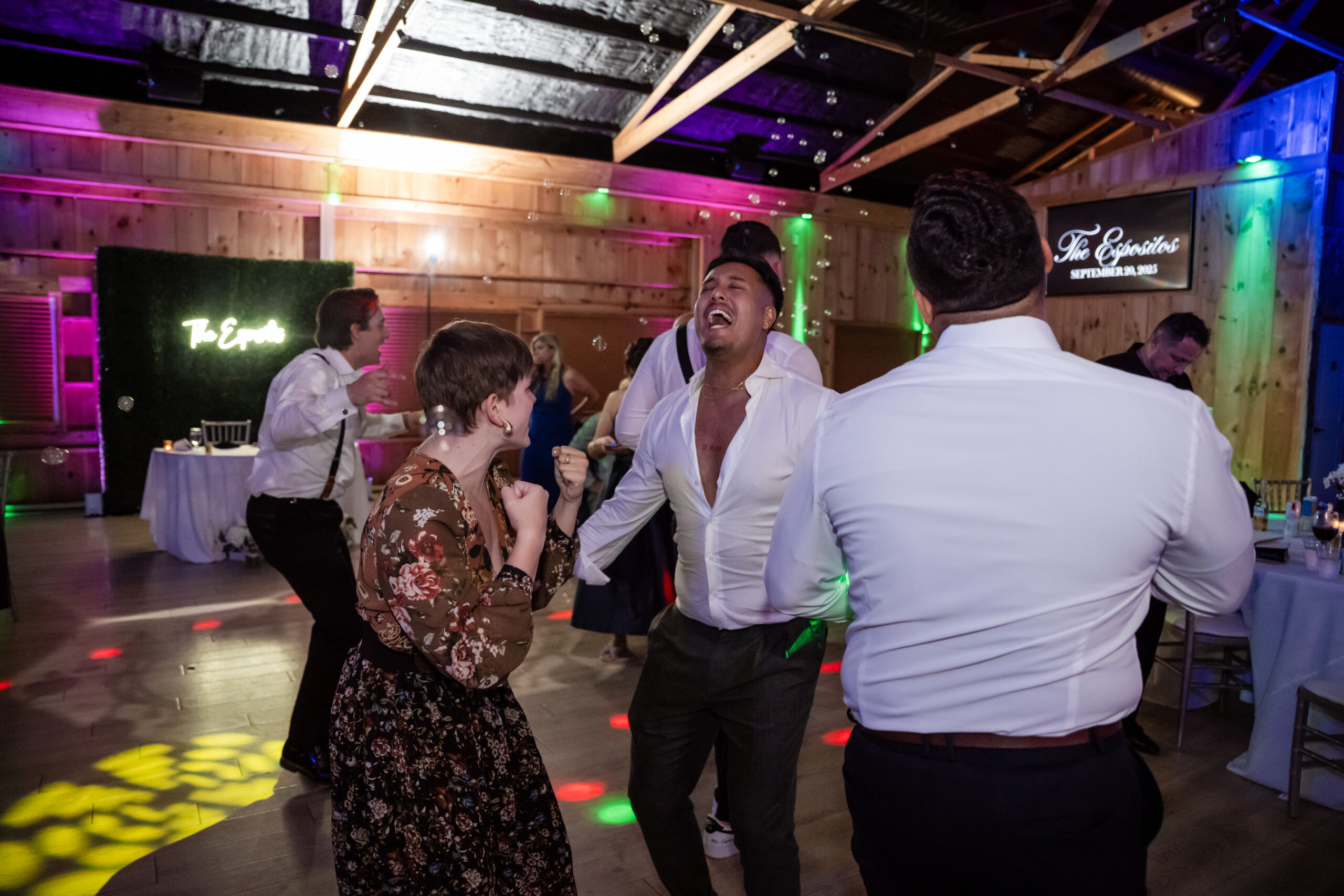 Wedding guests dancing joyfully on the dance floor during a lively black tie reception celebration