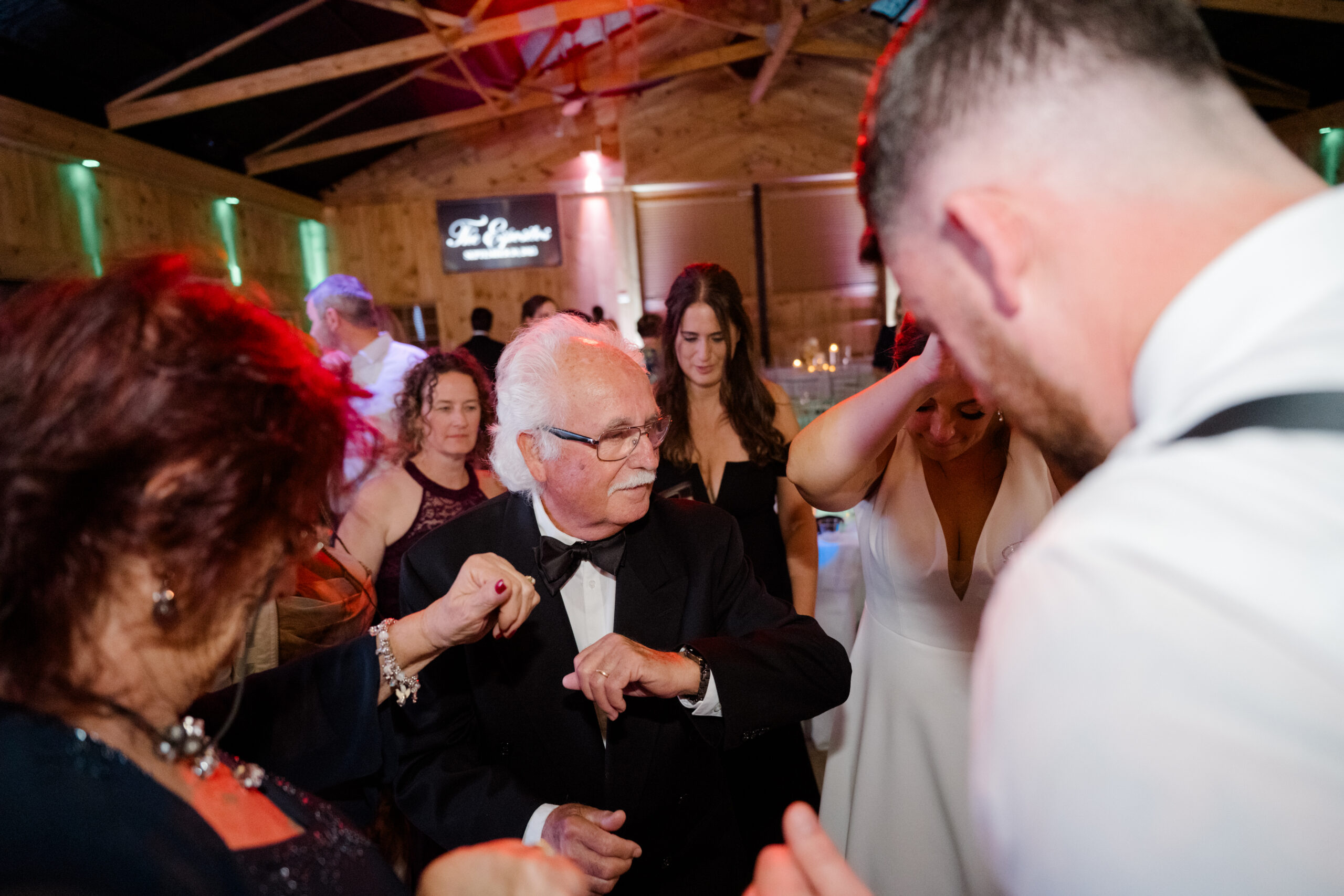 Older wedding guest dancing with family members during an emotional and joyful reception moment