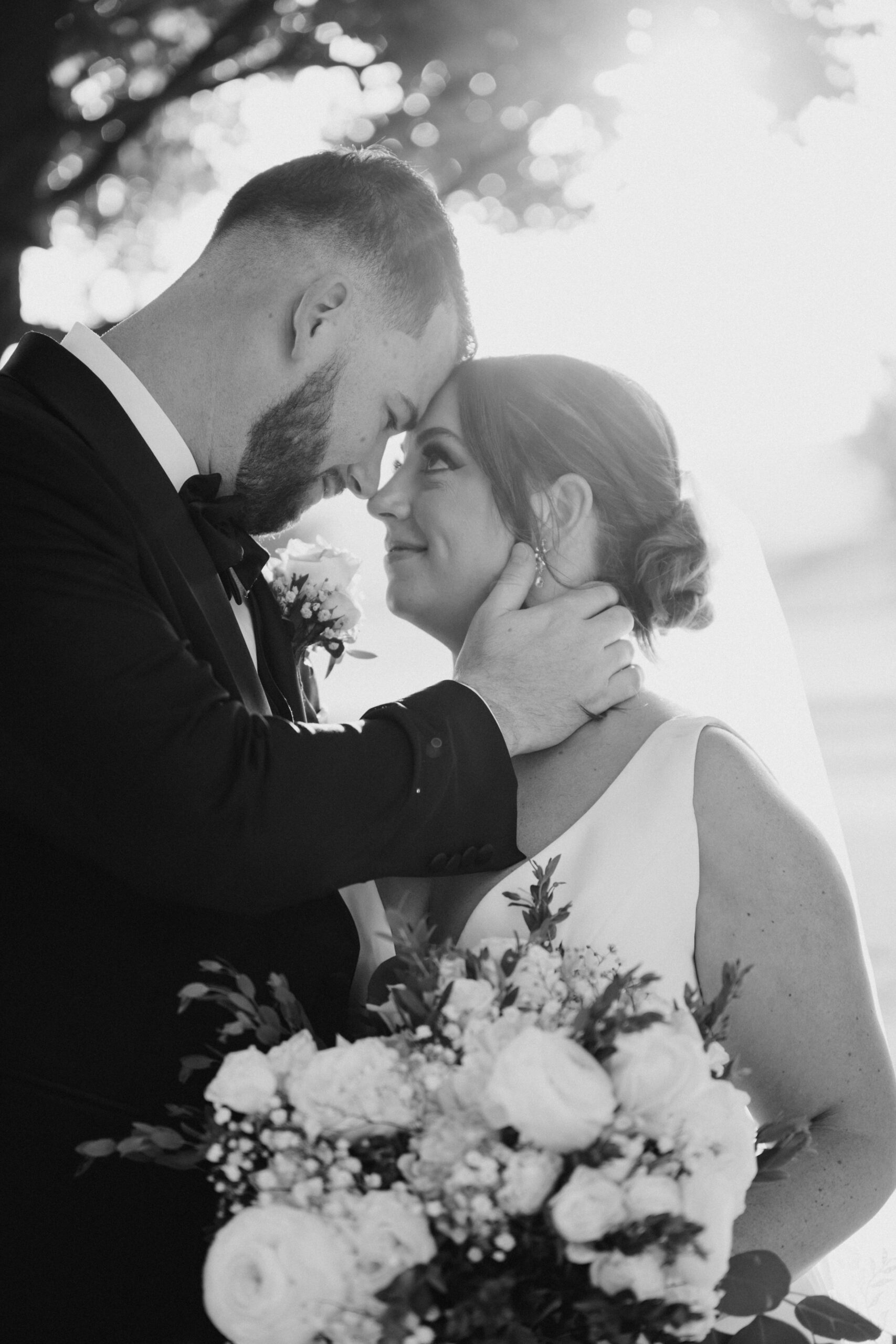 Black and white portrait of the bride and groom sharing an intimate moment during their wedding day