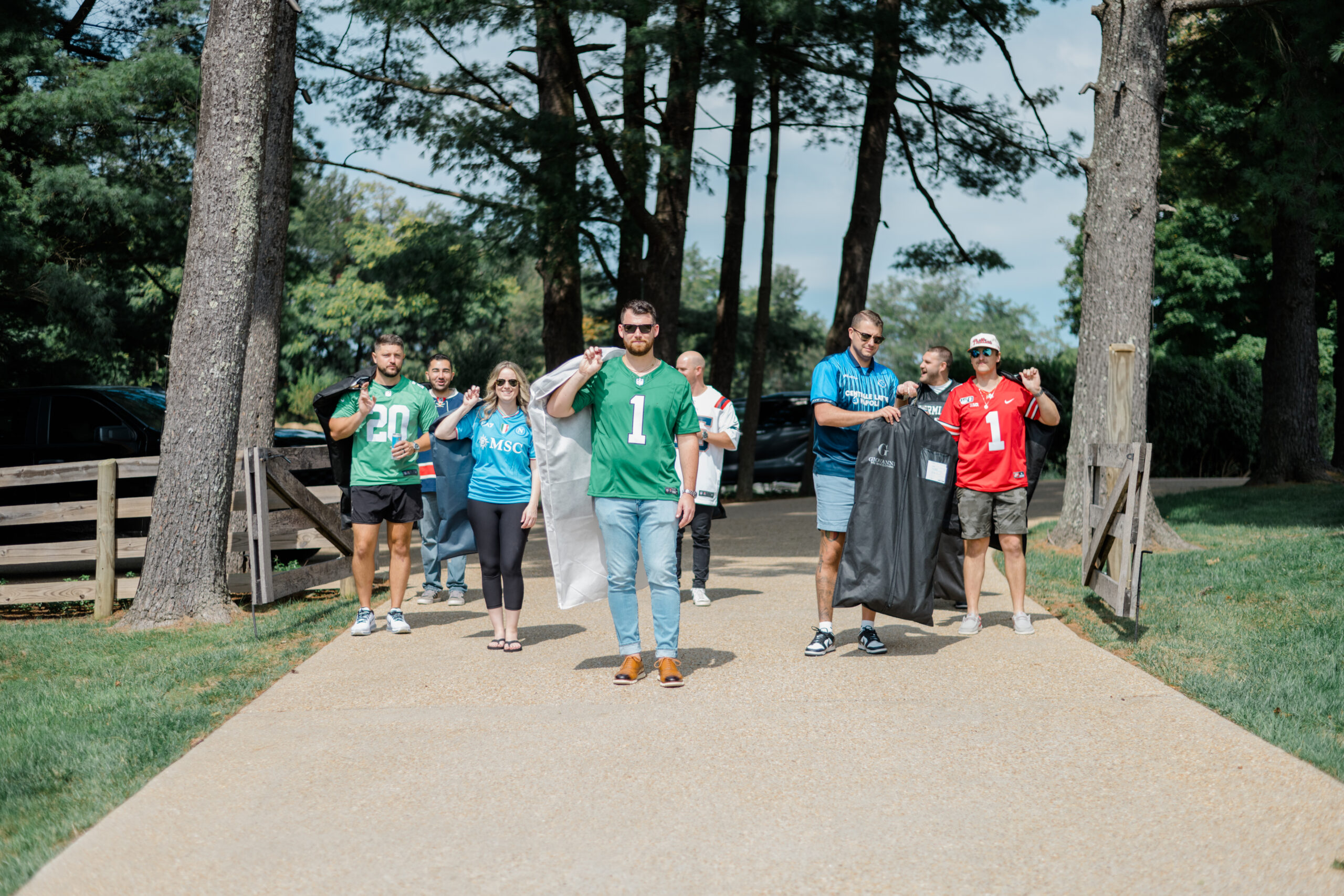 Friends arriving together before the ceremony carrying formal attire and celebrating the wedding day